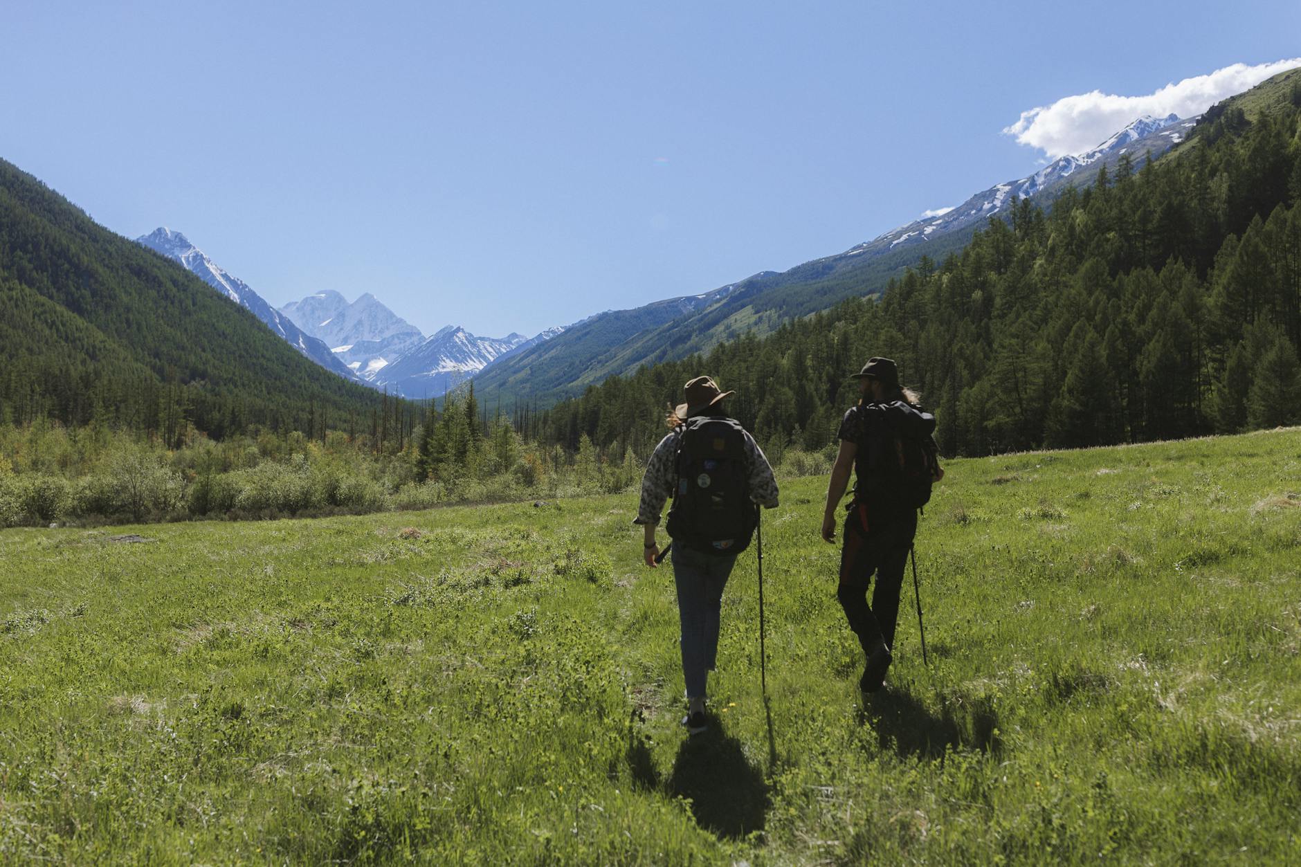 men walking on grassland near the mountains